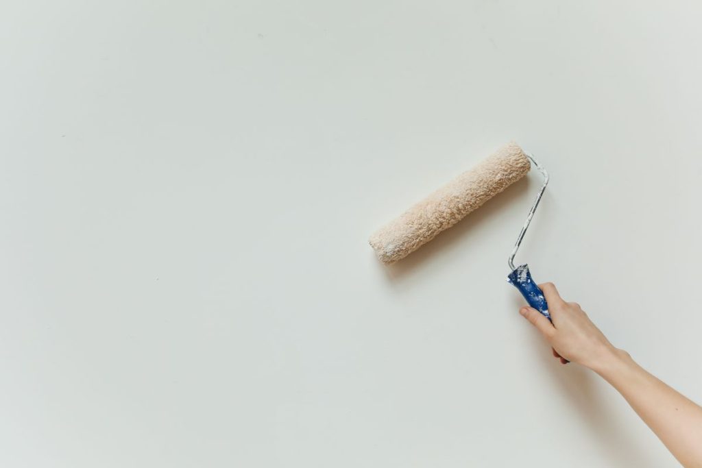 Painting a white wall with a roller
