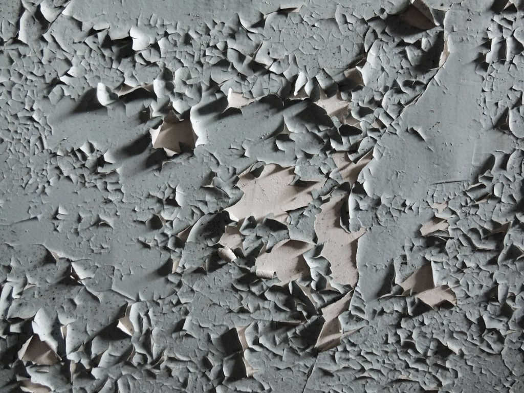 Cracked and peeling paint on an exterior wall