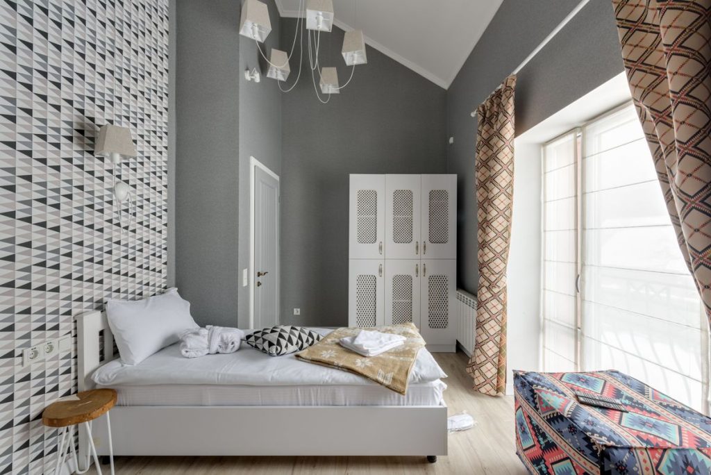 Bedroom with geometric patterned wallpaper on a feature wall